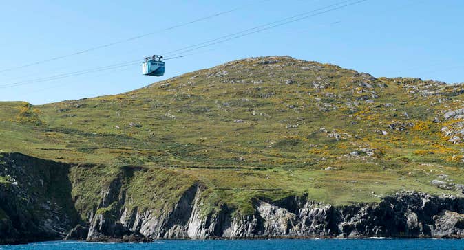 Cable car with land in the background and sea underneath