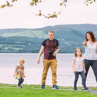 A family walking along a lake shoreline